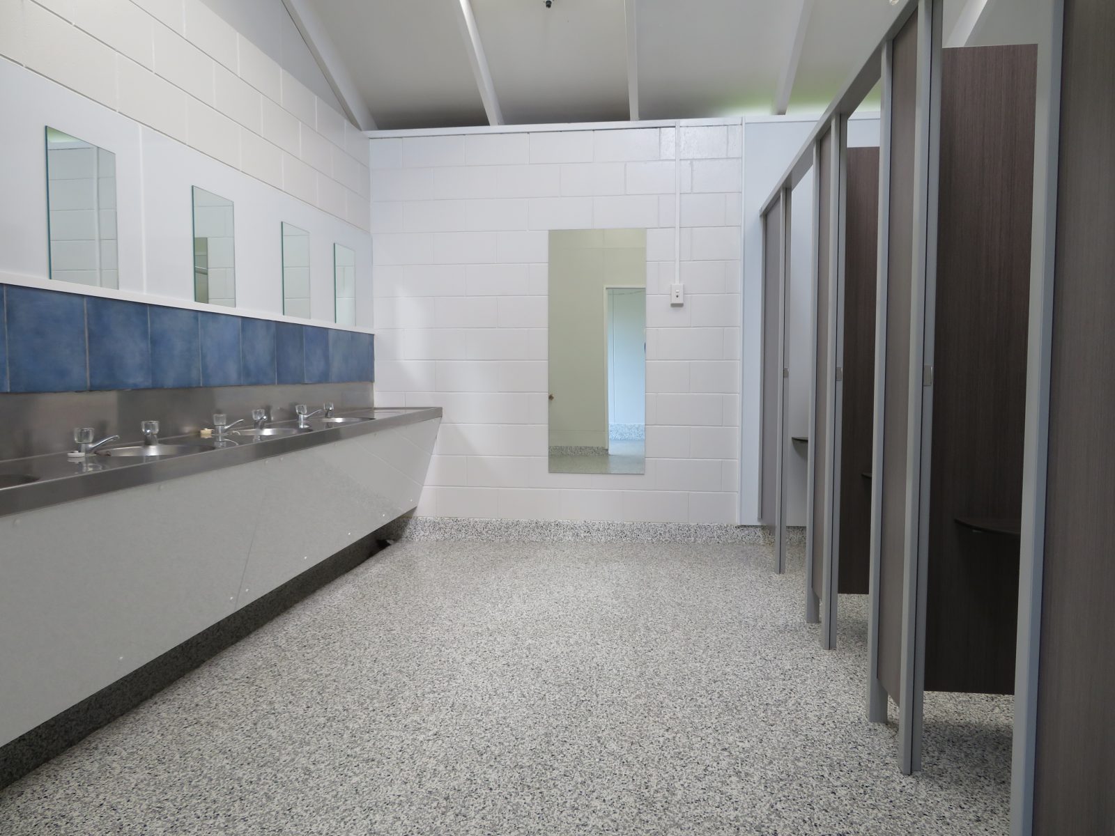 Renovated shower and toilet block with a row of hand basins, mirrors and private cubicles